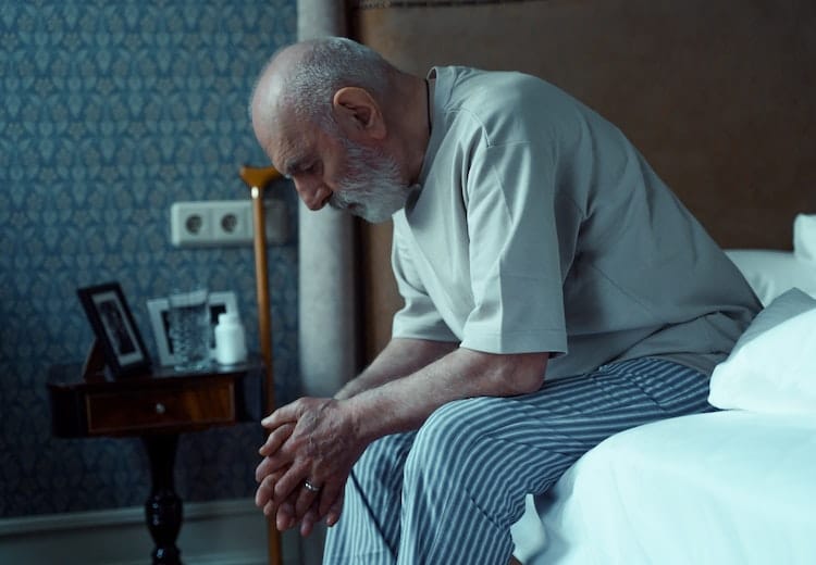 elderly-man-sitting-on-bed