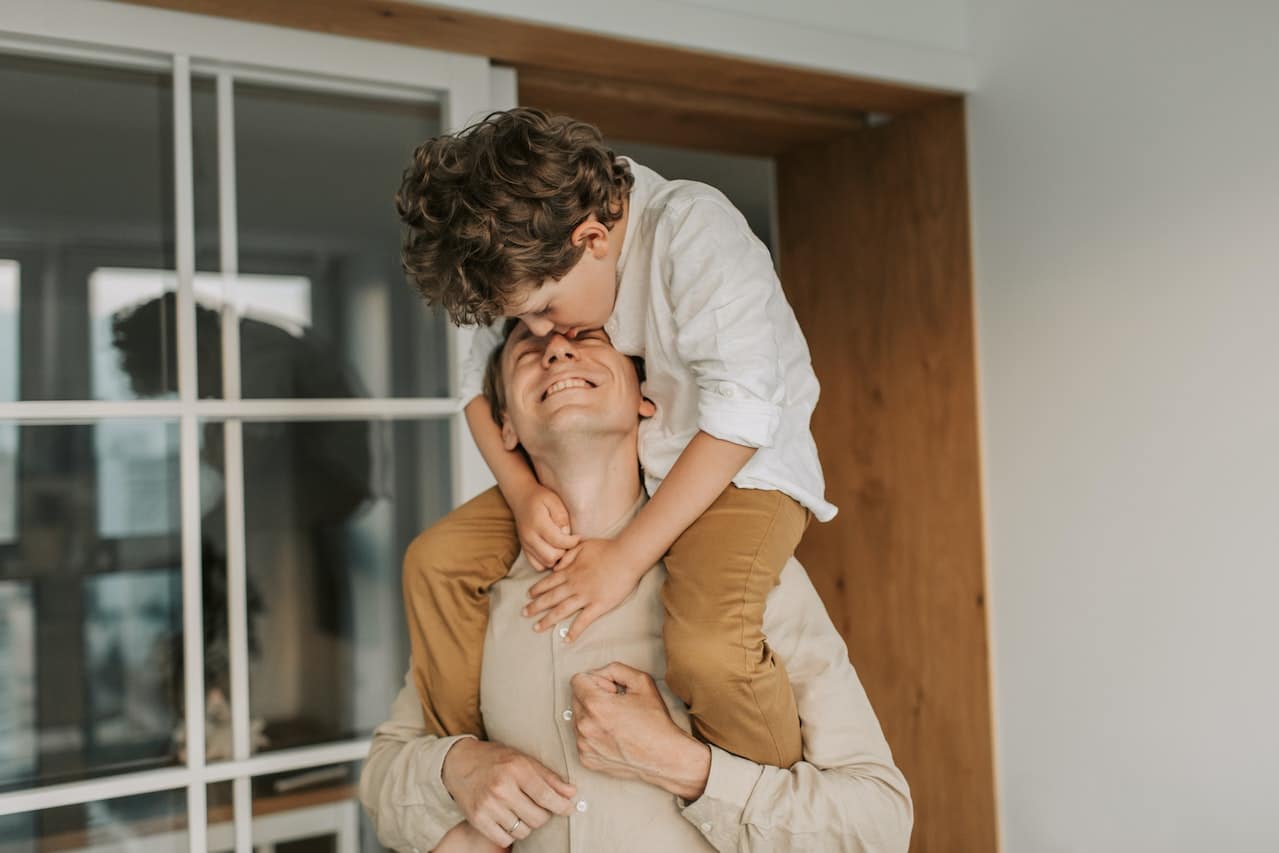 man carrying his son on shoulders